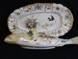 a fish shaped platter with a bird and flowers on it