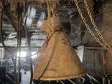 a large bell hanging from the ceiling of a building