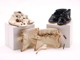 trois paires de chaussures de bébé posées sur une boîte blanche