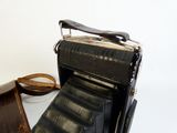 an old camera sitting on a table next to a suitcase