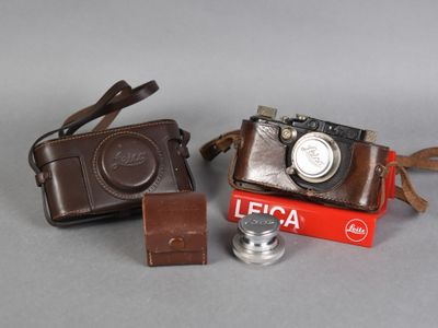 two cameras and a camera case sitting on a table