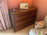 une chaise et une commode dans un coin de la pièce