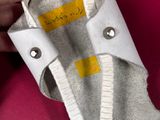 a person holding a pair of shoes with a label on them