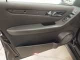 the interior of a car with the door open and a speaker in the passenger seat