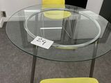 une table en verre avec une chaise jaune et une chaise jaune
