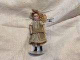 a doll that is sitting on a plate on a table