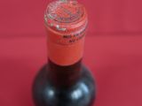 a bottle of wine sitting on a red surface