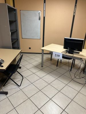 des tables et des chaises dans une pièce où se trouve un tableau blanc accroché au mur