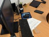 un bureau sur lequel se trouvent un écran, un clavier, une souris et un téléphone portable