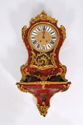 une horloge rouge et dorée accrochée au mur