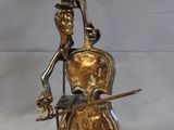 bronze sculpture of a cello player holding a bow and a bow