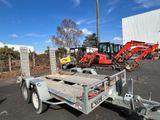 the trailer is parked in the parking lot with other equipment in the background