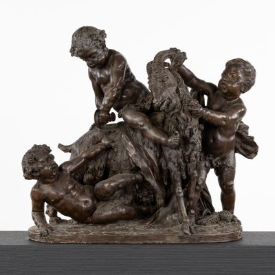 sculpture représentant un groupe d'enfants jouant avec un chien sur une table
