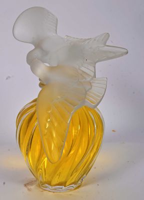 a yellow glass vase with a white bird on top of it
