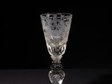 a wine glass sitting on a table with a black background