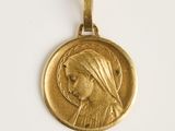 gros plan d'une médaille d'or sur une surface blanche