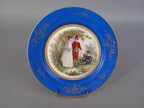 une assiette bleue sur laquelle est représenté un homme et une femme