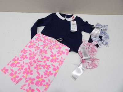 des vêtements et accessoires pour petite fille disposés sur une table