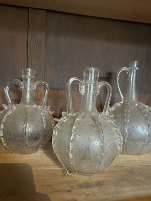 quatre vases en verre transparent posés sur une étagère en bois dans une pièce