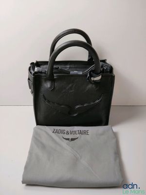 the small black bag is sitting next to a gray cloth
