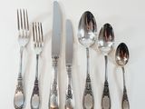 five spoons, a knife, and a fork on a table