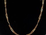 a gold chain necklace with a large link on a mannequin neck