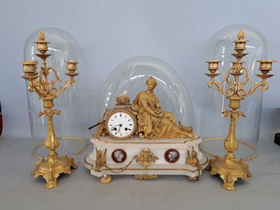 une horloge placée sous un dôme de verre sur une table