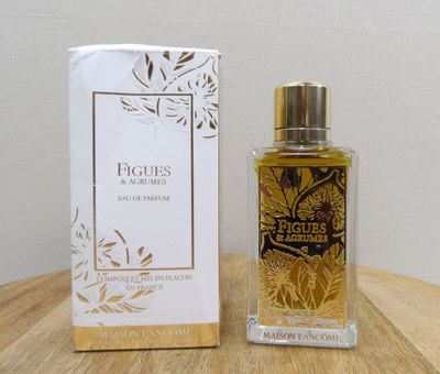 an image of a bottle of perfume sitting next to a box on a table
