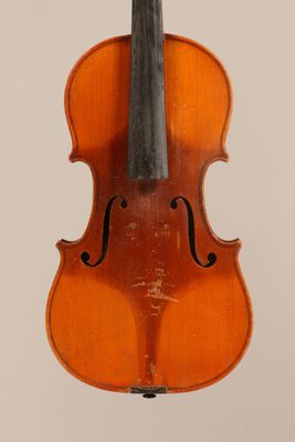 an old violin sitting on top of a white surface