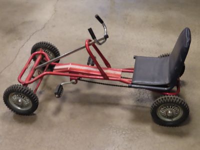 a small red tricycle with a black seat on the floor