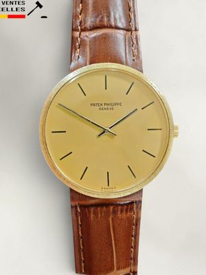 une image d'une montre en or avec un bracelet en cuir marron