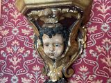 a picture of a wall sconce with a child ' s head on it
