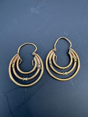 une paire de boucles d'oreilles en or sur une surface noire