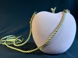 a white apple with a gold chain attached to it