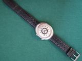 a watch that is laying on a green surface