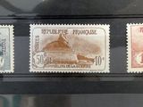 trois timbres différents exposés dans une vitrine posée sur une table