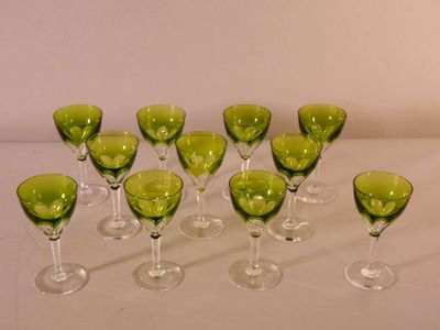 many green wine glasses lined up on a white table