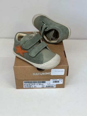 une boîte sur laquelle est posée une paire de chaussures de bébé