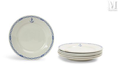 trois assiettes blanches bordées de bleu sont empilées les unes sur les autres