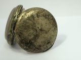 an antique pocket watch with a gold case sitting on a white surface