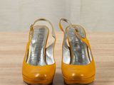 pair of yellow high heeled shoes sitting on top of a wooden table