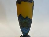 a blue and yellow vase sitting on a white surface
