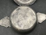 an old metal object on a table with a piece of paper