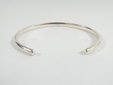 a close up of a silver cuff bracelet on a white background
