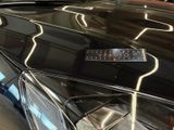 a shiny black car with a sticker on the hood