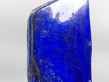 a blue stone sculpture on a wooden stand on a white background