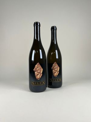 two bottles of wine sitting next to each other on a table