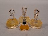 three bottles of perfume sitting on top of a table next to each other