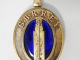 une image représentant un pendentif en verre bleu et plaqué or, orné d'une statue de la Liberté