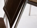 a chair that has a brown seat and a brown bag on it